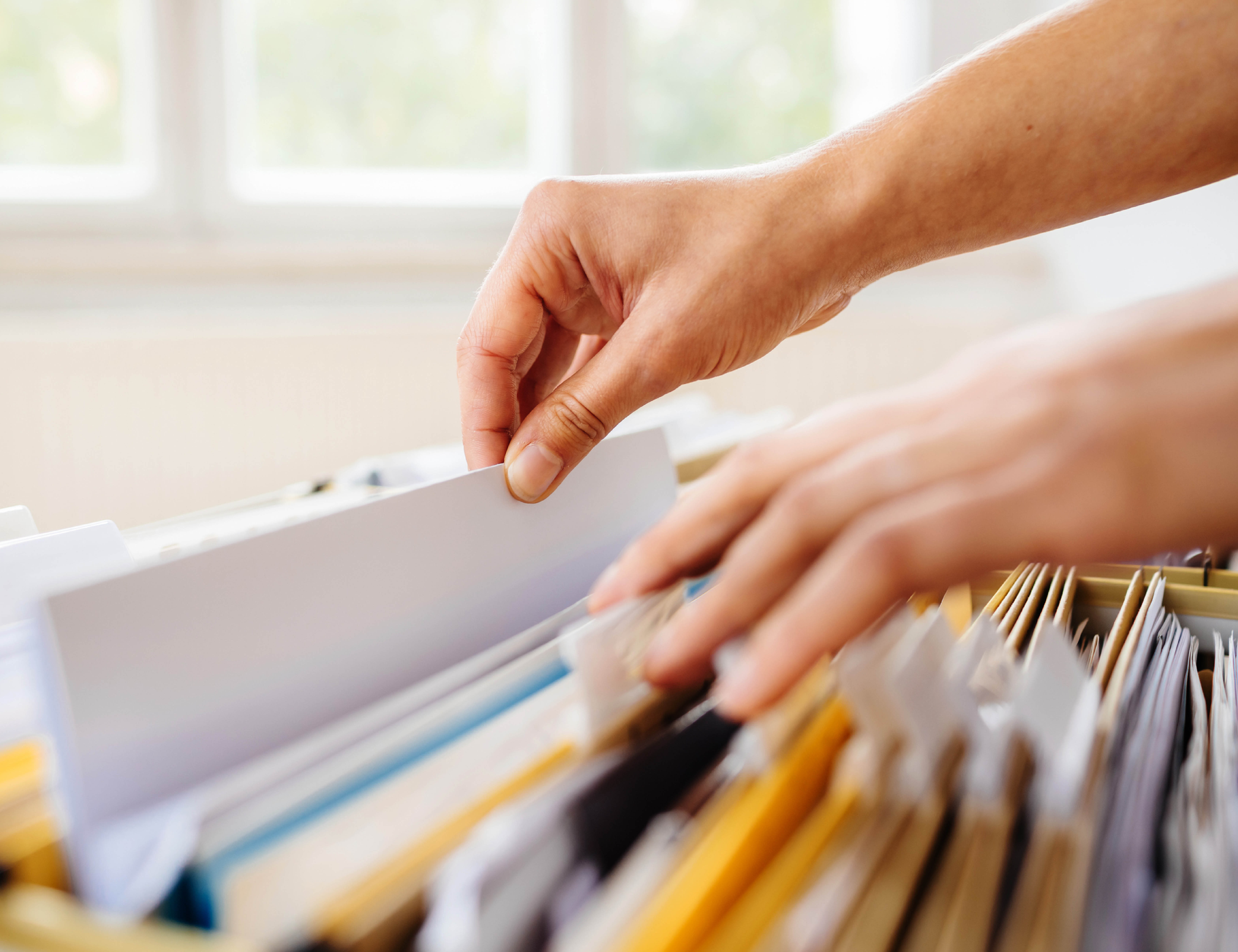 A woman sorts file folders for students. 