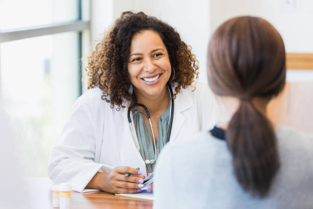 Caregiver sitting down talking with a young female patient